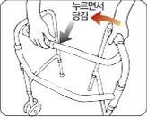 가운데 접이버튼을 누르면서 손잡이를 안쪽으로 밀어 접는 모습